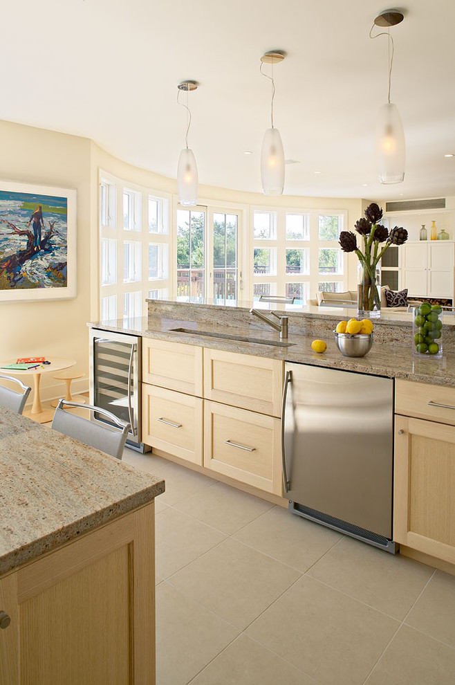 Cette image montre une cuisine ouverte marine en bois clair avec un électroménager en acier inoxydable, un placard avec porte à panneau encastré et un plan de travail en granite.