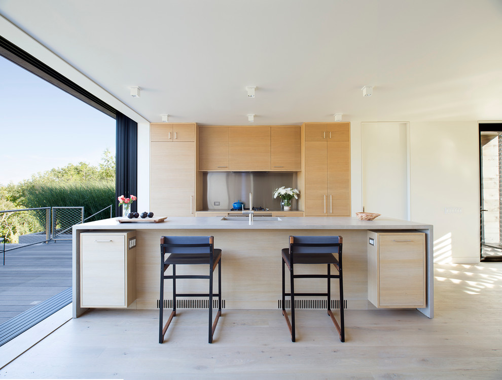 Стильный дизайн: параллельная кухня-гостиная среднего размера в морском стиле с плоскими фасадами, светлыми деревянными фасадами, светлым паркетным полом, островом, столешницей из бетона и врезной мойкой - последний тренд