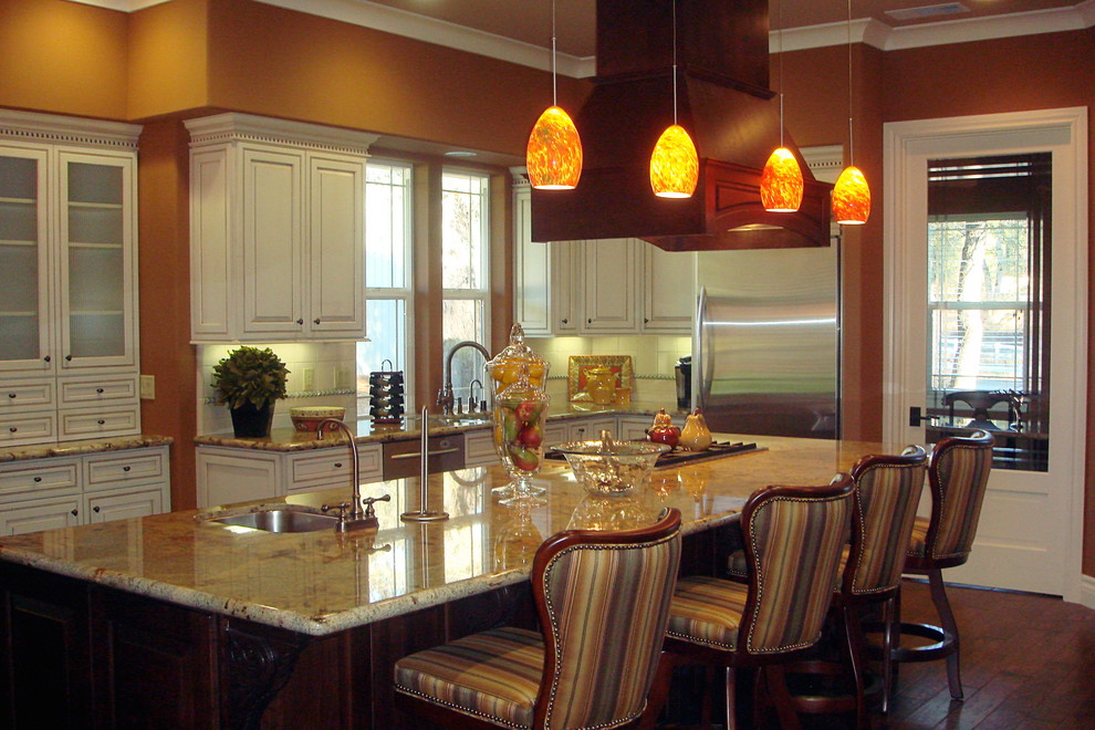 Foto di una cucina classica con ante con bugna sagomata, ante bianche, paraspruzzi beige e elettrodomestici in acciaio inossidabile