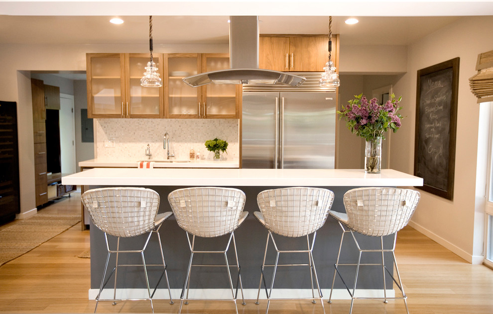 Immagine di una cucina parallela contemporanea con paraspruzzi con piastrelle a mosaico, elettrodomestici in acciaio inossidabile, ante di vetro, ante in legno chiaro e paraspruzzi bianco