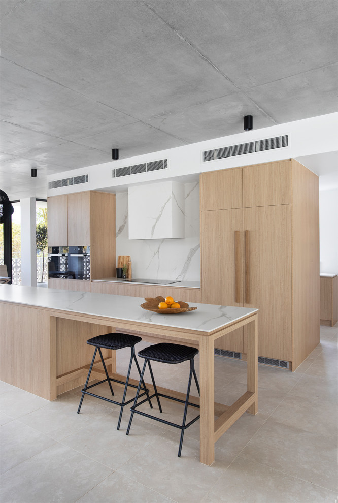 Zweizeilige Moderne Küche mit flächenbündigen Schrankfronten, hellen Holzschränken, Küchenrückwand in Weiß, Rückwand aus Stein, Elektrogeräten mit Frontblende, Kücheninsel, grauem Boden und weißer Arbeitsplatte in Brisbane