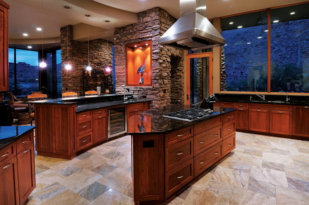 Example of a tuscan open concept kitchen design in Phoenix with shaker cabinets and dark wood cabinets