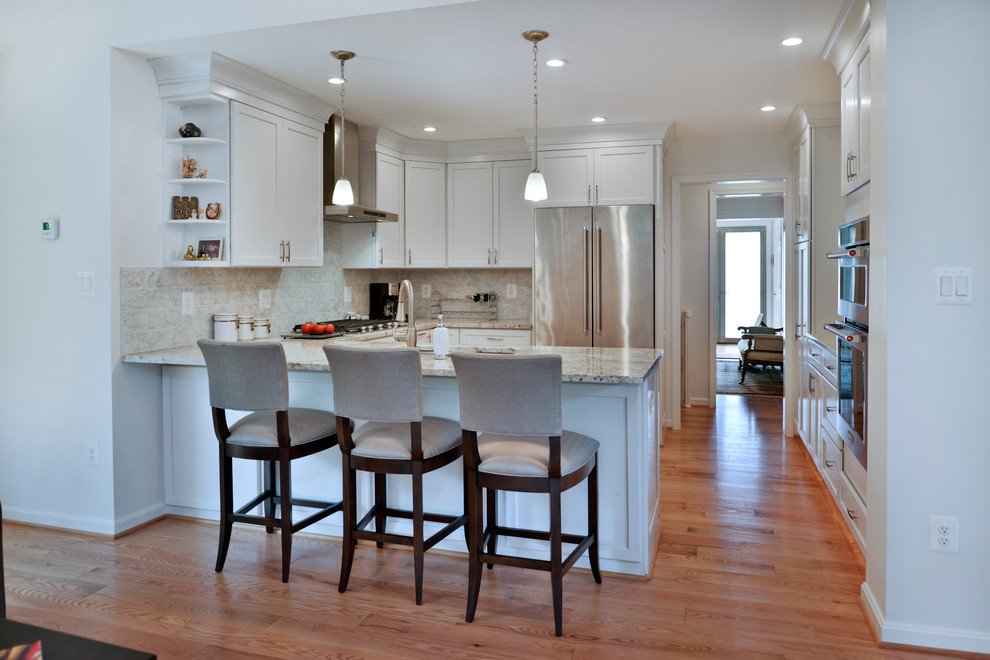 ワシントンD.C.にあるラグジュアリーな巨大なモダンスタイルのおしゃれなキッチン (ダブルシンク、白いキャビネット、グレーのキッチンパネル、シルバーの調理設備、淡色無垢フローリング、茶色い床、グレーのキッチンカウンター) の写真