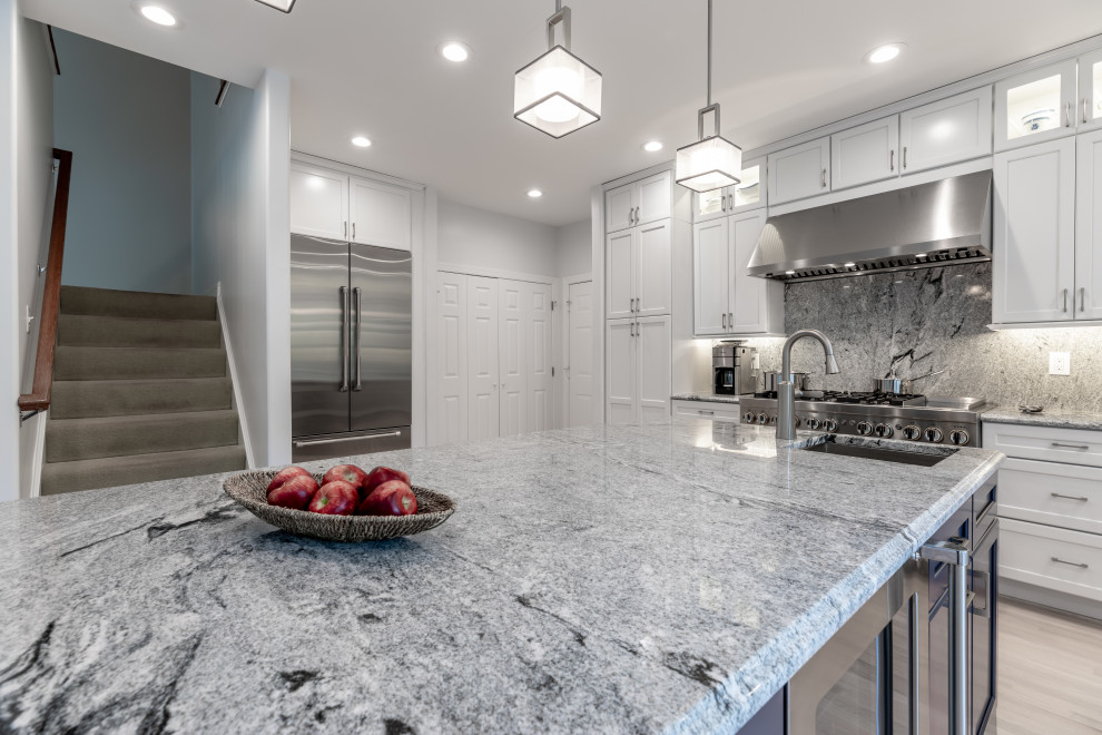 Mittelgroße Moderne Wohnküche mit weißen Schränken, Granit-Arbeitsplatte, Küchengeräten aus Edelstahl, Kücheninsel und grauem Boden in Washington, D.C.