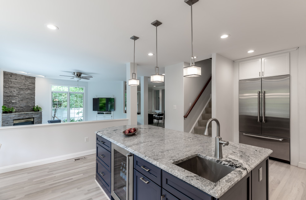 This is an example of a medium sized contemporary kitchen/diner in DC Metro with white cabinets, granite worktops, stainless steel appliances, an island and grey floors.