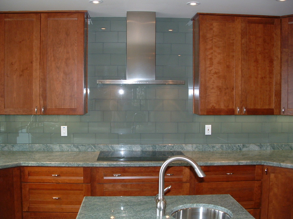 Inredning av ett modernt stort kök och matrum, med en undermonterad diskho, skåp i shakerstil, skåp i mellenmörkt trä, granitbänkskiva, grönt stänkskydd, stänkskydd i glaskakel, rostfria vitvaror, skiffergolv och en köksö