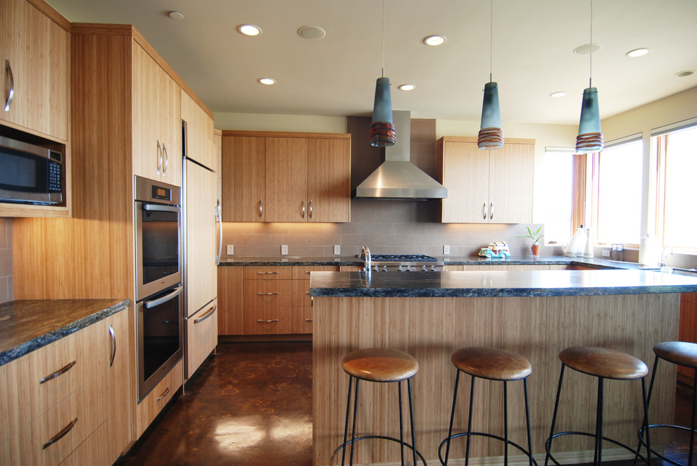 Immagine di una grande cucina moderna con ante lisce, ante in legno chiaro, top in granito, paraspruzzi nero, paraspruzzi con piastrelle di cemento e elettrodomestici in acciaio inossidabile
