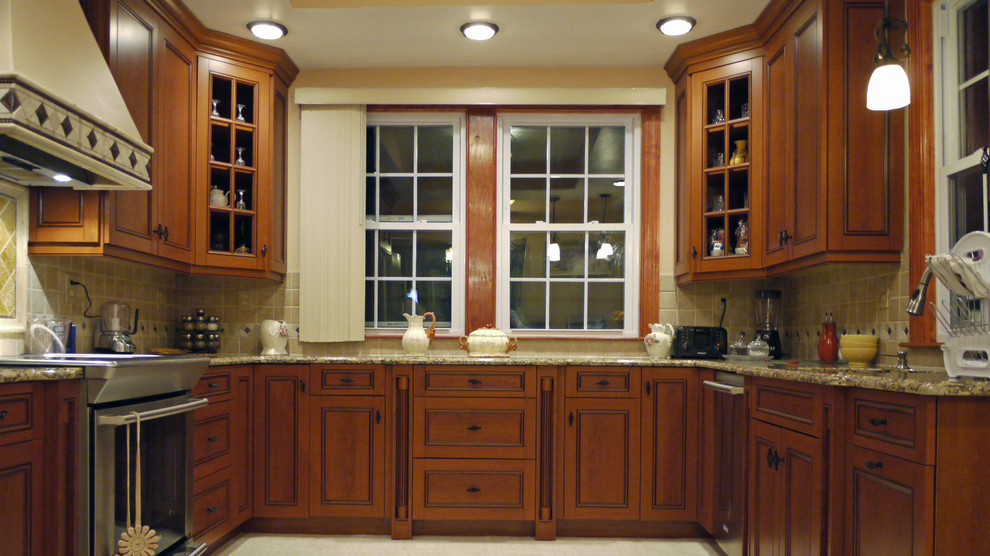 Example of a mid-sized classic u-shaped porcelain tile eat-in kitchen design in Boston with a single-bowl sink, recessed-panel cabinets, medium tone wood cabinets, granite countertops, beige backsplash, porcelain backsplash, stainless steel appliances and an island