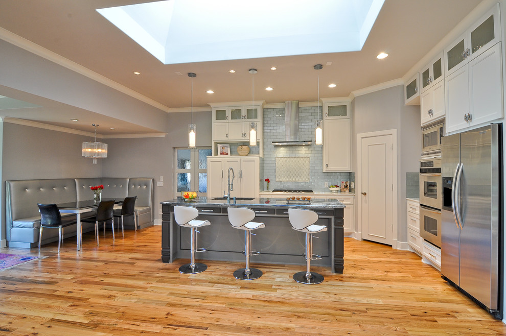 Immagine di una cucina classica con lavello sottopiano, ante in stile shaker, ante bianche, top in granito, paraspruzzi a effetto metallico e elettrodomestici in acciaio inossidabile