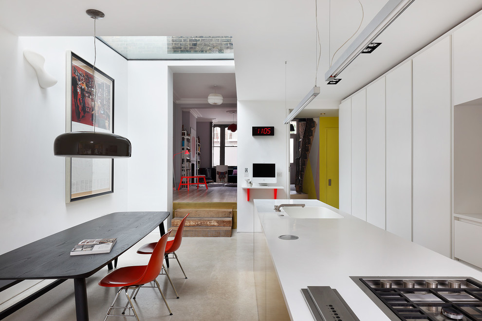 Zweizeilige Moderne Wohnküche mit integriertem Waschbecken, flächenbündigen Schrankfronten, weißen Schränken, Kücheninsel und beigem Boden in London