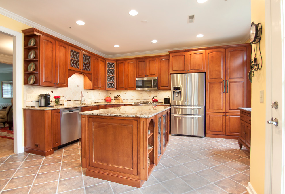 Tuscan l-shaped ceramic tile kitchen photo in DC Metro with an undermount sink, raised-panel cabinets, medium tone wood cabinets, granite countertops, beige backsplash, stainless steel appliances and an island