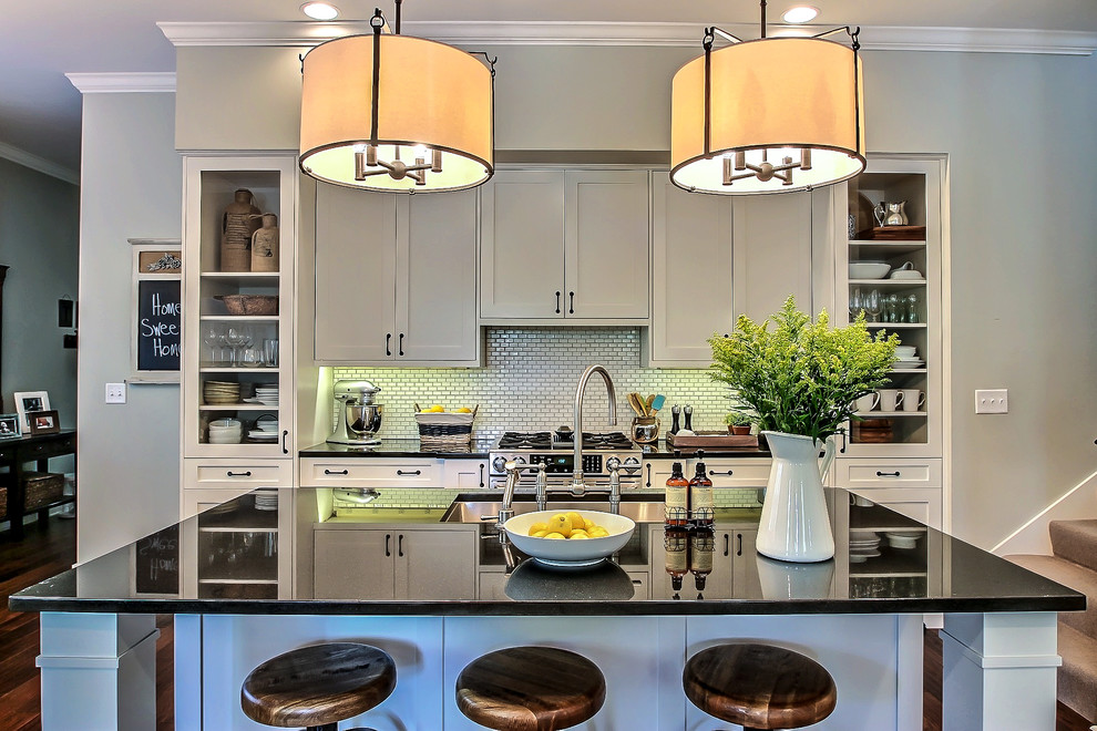 Inspiration for a small transitional galley dark wood floor open concept kitchen remodel in Jacksonville with a single-bowl sink, shaker cabinets, white cabinets, granite countertops, white backsplash, porcelain backsplash, stainless steel appliances and an island