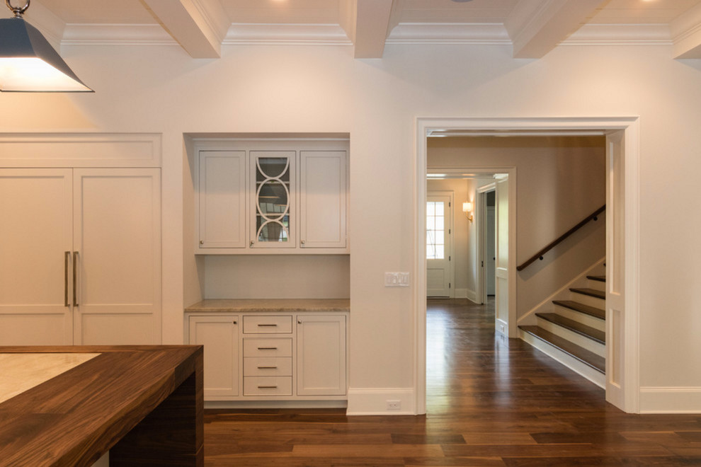 Example of a large transitional medium tone wood floor kitchen design in Charlotte with recessed-panel cabinets, white cabinets and marble countertops