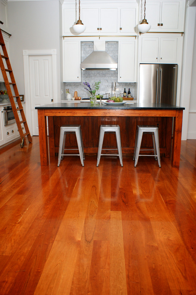Moderne Küche mit Küchengeräten aus Edelstahl, braunem Holzboden und Kücheninsel in Providence