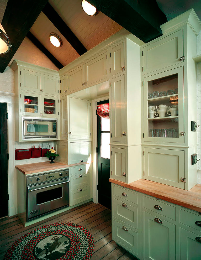 Idéer för stora lantliga brunt kök, med en nedsänkt diskho, luckor med infälld panel, blå skåp, träbänkskiva, vitt stänkskydd, stänkskydd i tegel, rostfria vitvaror, mellanmörkt trägolv, en halv köksö och brunt golv