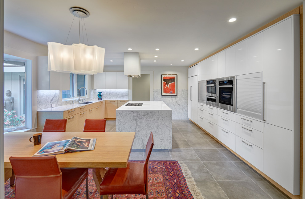 Inspiration for a large modern u-shaped kitchen/diner in Sacramento with a submerged sink, flat-panel cabinets, white cabinets, engineered stone countertops, white splashback, marble splashback, stainless steel appliances, porcelain flooring, an island and grey floors.