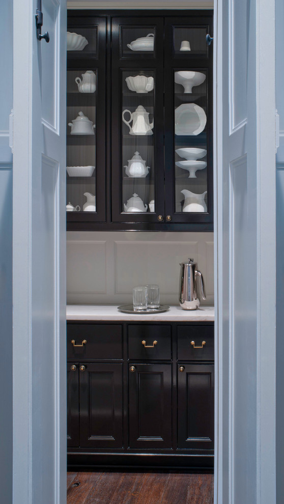 Modelo de cocina comedor lineal clásica con fregadero encastrado, armarios con paneles empotrados, puertas de armario negras, encimera de mármol y salpicadero blanco