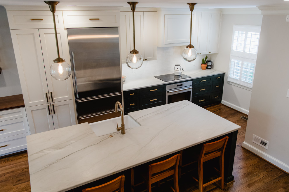 Bild på ett mellanstort funkis vit linjärt vitt kök och matrum, med en rustik diskho, skåp i shakerstil, vita skåp, marmorbänkskiva, vitt stänkskydd, stänkskydd i tunnelbanekakel, rostfria vitvaror, mörkt trägolv, en köksö och brunt golv