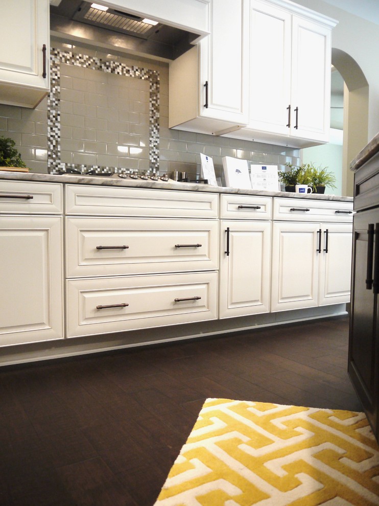 Example of a large transitional l-shaped dark wood floor eat-in kitchen design in Grand Rapids with an undermount sink, raised-panel cabinets, white cabinets, granite countertops, gray backsplash, subway tile backsplash, stainless steel appliances and an island