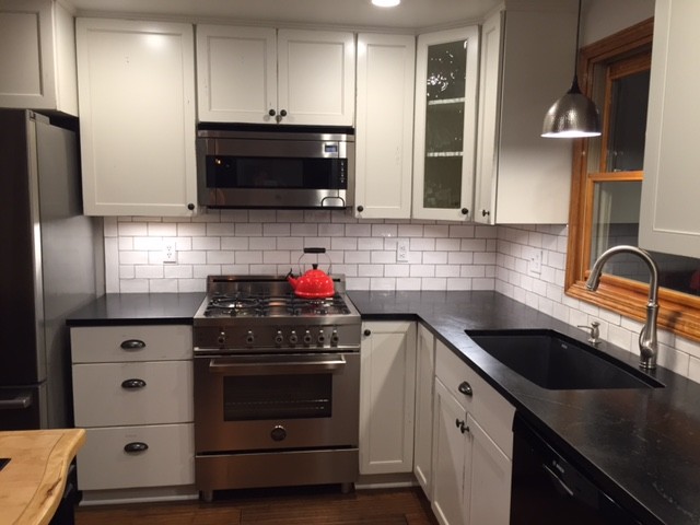 ニューヨークにある小さなモダンスタイルのおしゃれなキッチン (シェーカースタイル扉のキャビネット、白いキャビネット、ソープストーンカウンター、白いキッチンパネル、サブウェイタイルのキッチンパネル、シルバーの調理設備、濃色無垢フローリング、アンダーカウンターシンク) の写真