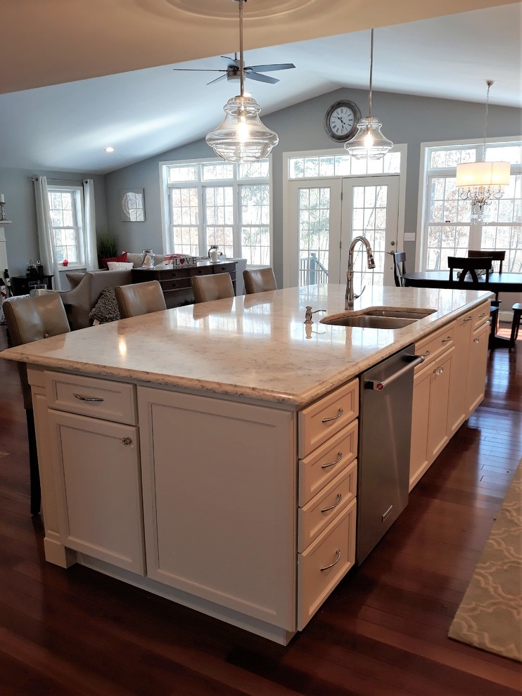 Idéer för att renovera ett stort vintage vit vitt kök, med en dubbel diskho, luckor med infälld panel, vita skåp, bänkskiva i kvarts, vitt stänkskydd, stänkskydd i keramik, rostfria vitvaror, mellanmörkt trägolv, en köksö och brunt golv