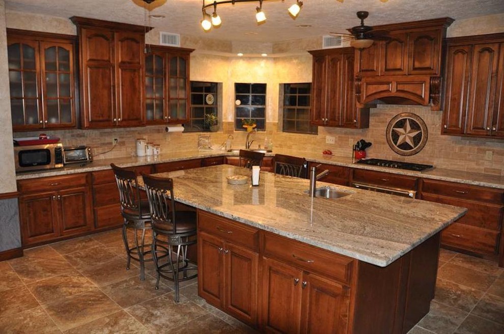 Photo of a large classic l-shaped kitchen/diner in Houston with a submerged sink, raised-panel cabinets, medium wood cabinets, granite worktops, beige splashback, ceramic splashback, stainless steel appliances, ceramic flooring and an island.