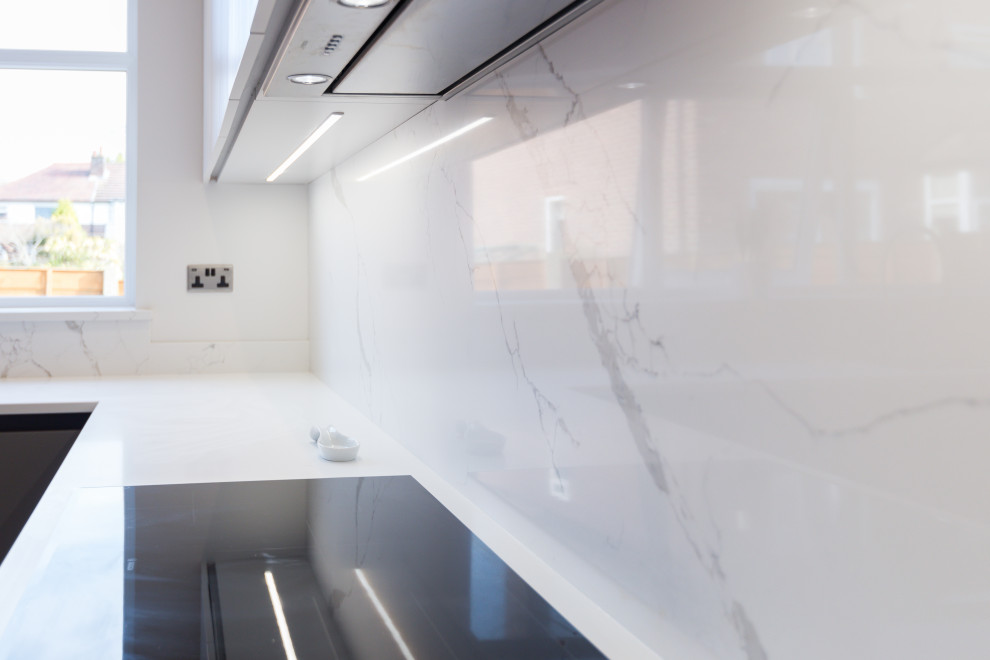 Exempel på ett stort modernt vit vitt kök, med en undermonterad diskho, släta luckor, grå skåp, marmorbänkskiva, vitt stänkskydd, stänkskydd i marmor, integrerade vitvaror, vinylgolv, en halv köksö och brunt golv