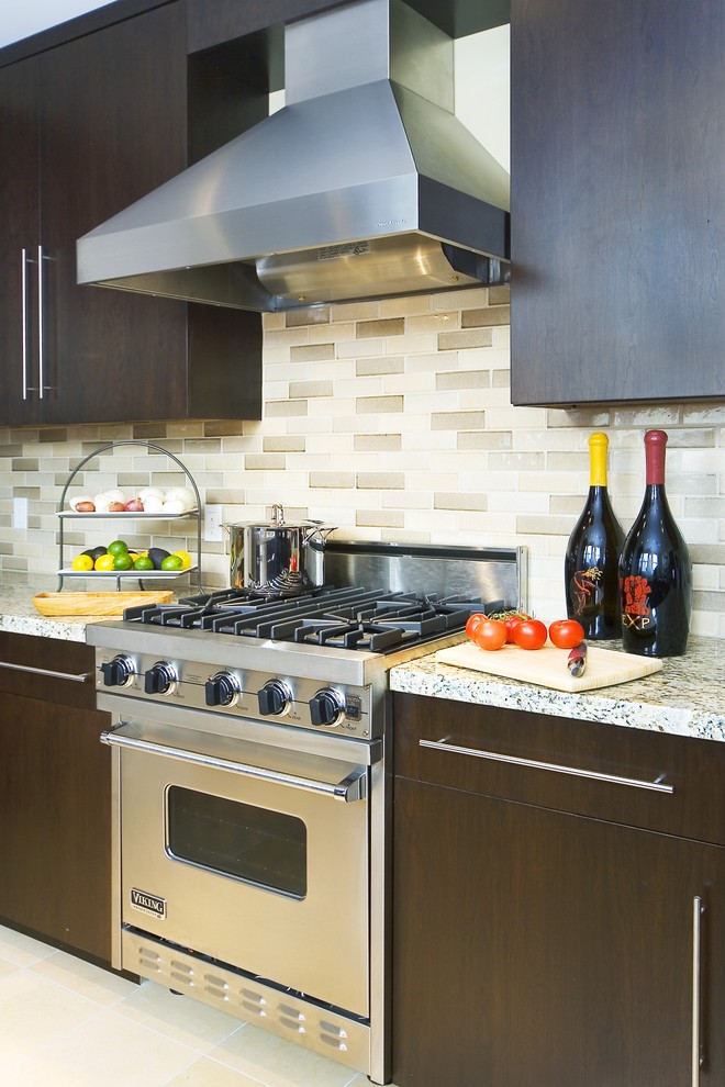 Immagine di una cucina minimal con ante lisce, ante in legno bruno, paraspruzzi con piastrelle diamantate, elettrodomestici in acciaio inossidabile e paraspruzzi multicolore