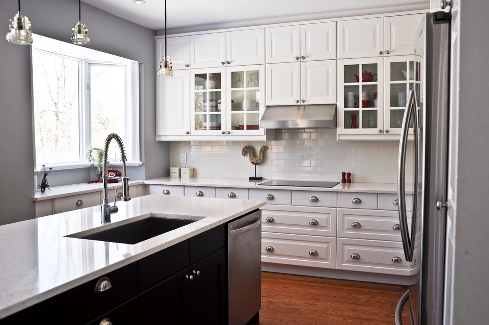 Idéer för ett klassiskt kök och matrum, med en undermonterad diskho, luckor med upphöjd panel, vita skåp, bänkskiva i kvarts, vitt stänkskydd, stänkskydd i porslinskakel, rostfria vitvaror och en köksö