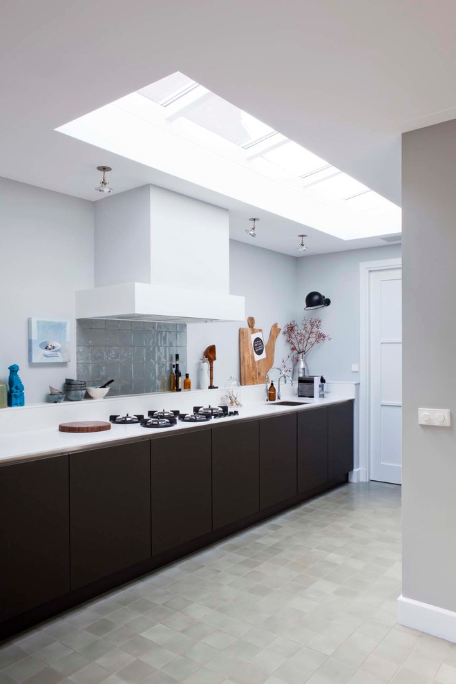 This is an example of a scandinavian galley kitchen in Amsterdam with flat-panel cabinets, dark wood cabinets, grey splashback and no island.