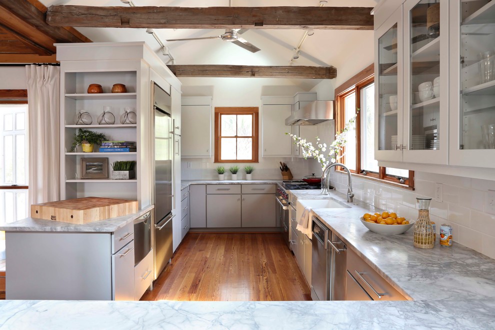 На фото: кухня в морском стиле с техникой из нержавеющей стали, фартуком из плитки кабанчик, врезной мойкой и окном