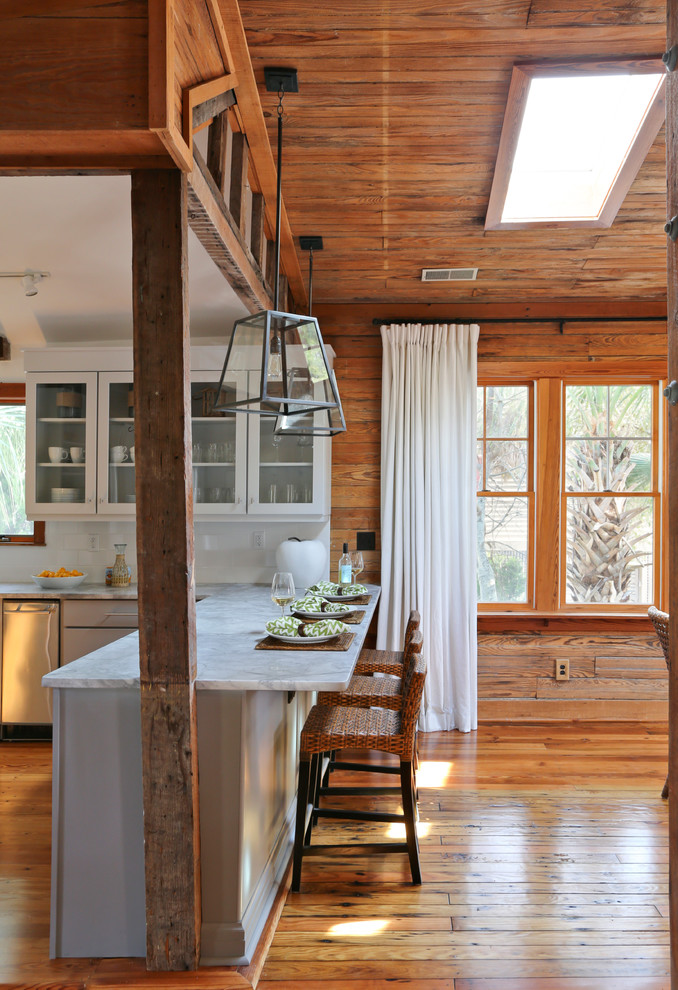 Eat-in kitchen - coastal eat-in kitchen idea in San Francisco with glass-front cabinets, white cabinets, white backsplash, subway tile backsplash and stainless steel appliances