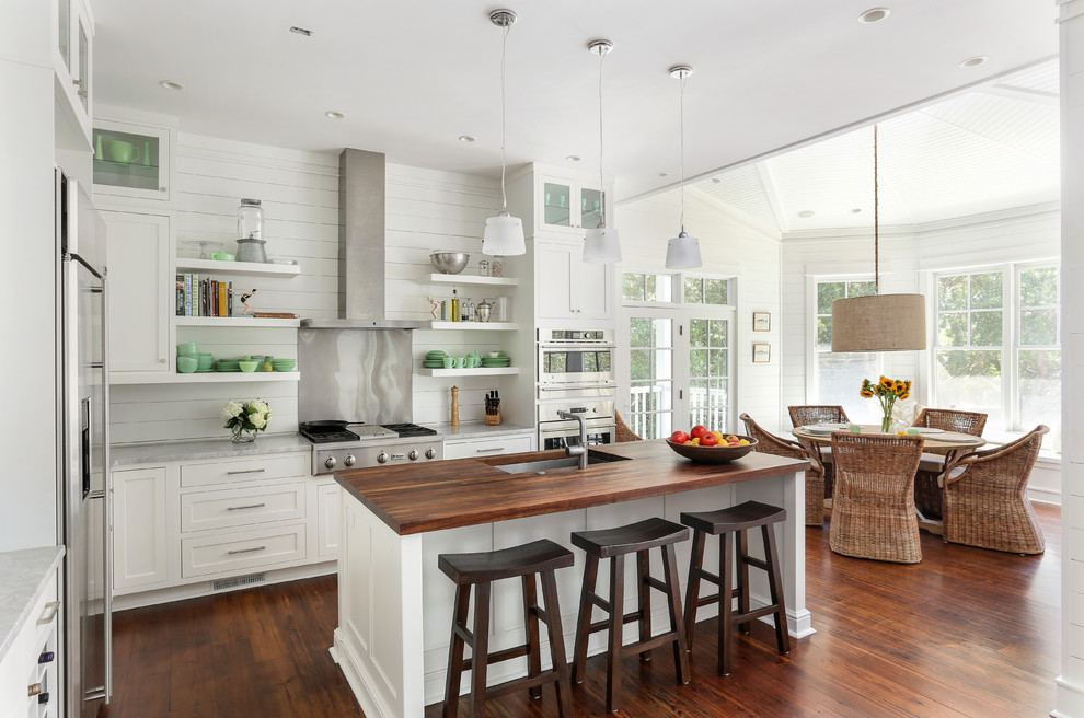 Example of a beach style eat-in kitchen design in San Francisco with an undermount sink, shaker cabinets, white cabinets, stainless steel appliances, wood countertops, metallic backsplash and metal backsplash