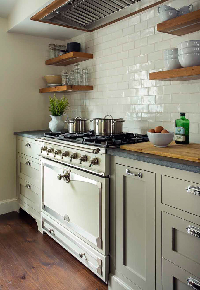 Inspiration för ett litet lantligt kök, med en rustik diskho, luckor med infälld panel, grå skåp, bänkskiva i täljsten, vitt stänkskydd, stänkskydd i keramik, vita vitvaror, mörkt trägolv och en köksö