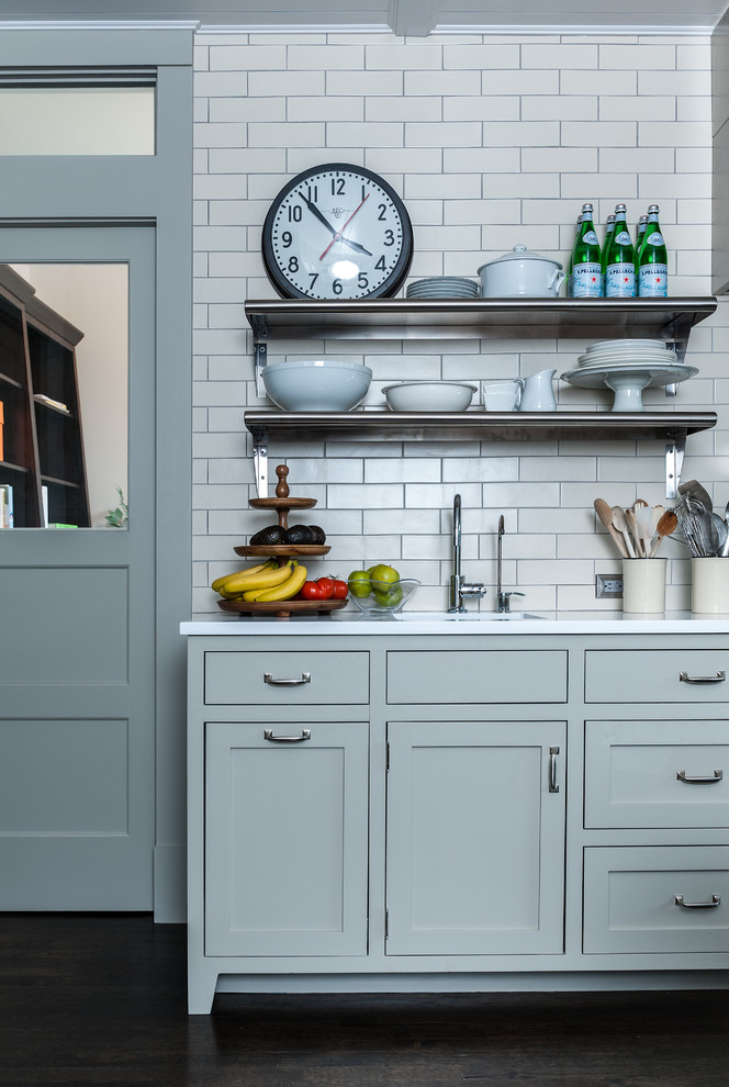 Exemple d'une cuisine tendance avec un placard à porte shaker, des portes de placard grises, un plan de travail en quartz modifié, une crédence blanche et une crédence en carrelage métro.