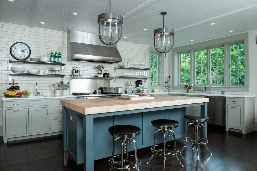 Example of a trendy kitchen design in New York with open cabinets, subway tile backsplash, wood countertops, white backsplash, gray cabinets and stainless steel appliances
