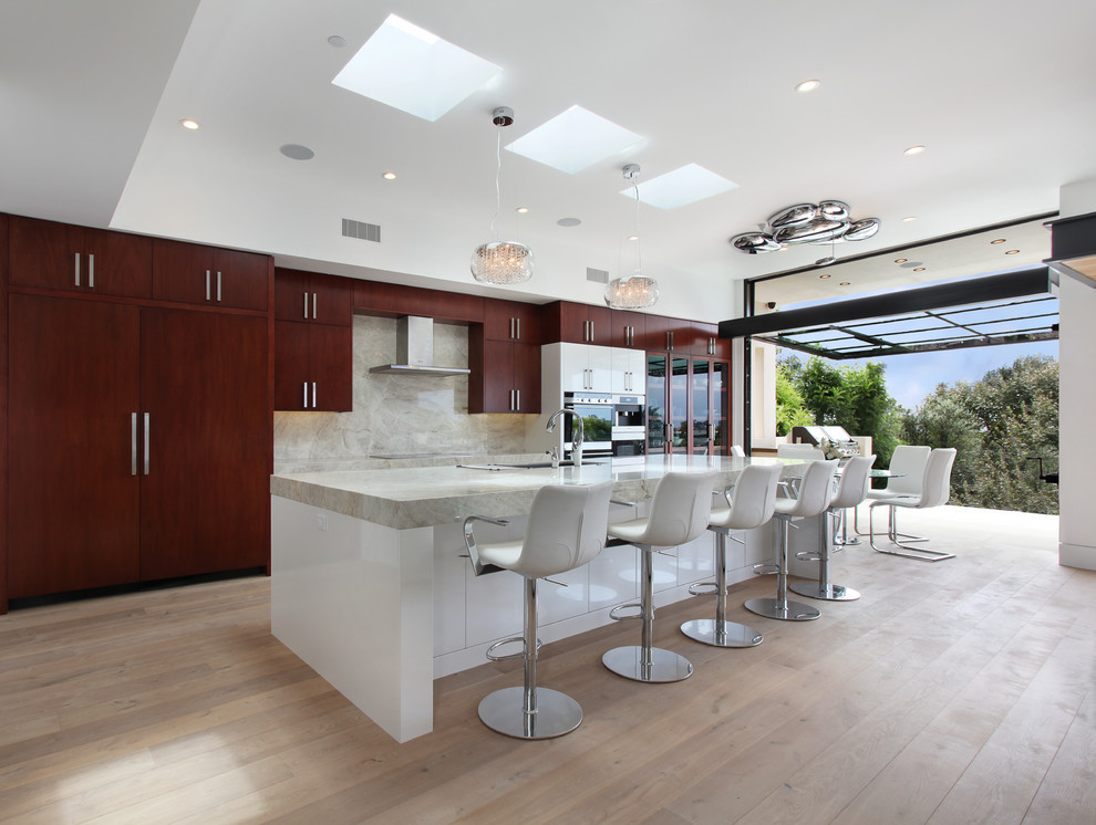 Foto di un cucina con isola centrale minimal con lavello sottopiano, ante lisce, ante in legno scuro, paraspruzzi bianco e parquet chiaro
