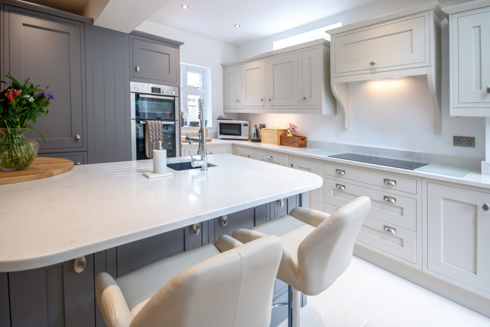 This is an example of a contemporary l-shaped kitchen/diner in Other with an integrated sink, grey cabinets, quartz worktops, an island and beige worktops.