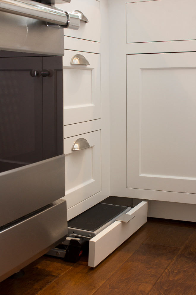 Example of a small transitional u-shaped dark wood floor and brown floor eat-in kitchen design in Raleigh with an undermount sink, recessed-panel cabinets, white cabinets, quartz countertops, white backsplash, subway tile backsplash, stainless steel appliances, no island and beige countertops