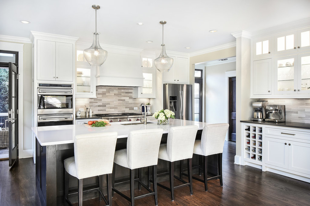 Large classic kitchen in Atlanta with a submerged sink, white cabinets, engineered stone countertops, stainless steel appliances, dark hardwood flooring, an island, glass-front cabinets, multi-coloured splashback and limestone splashback.