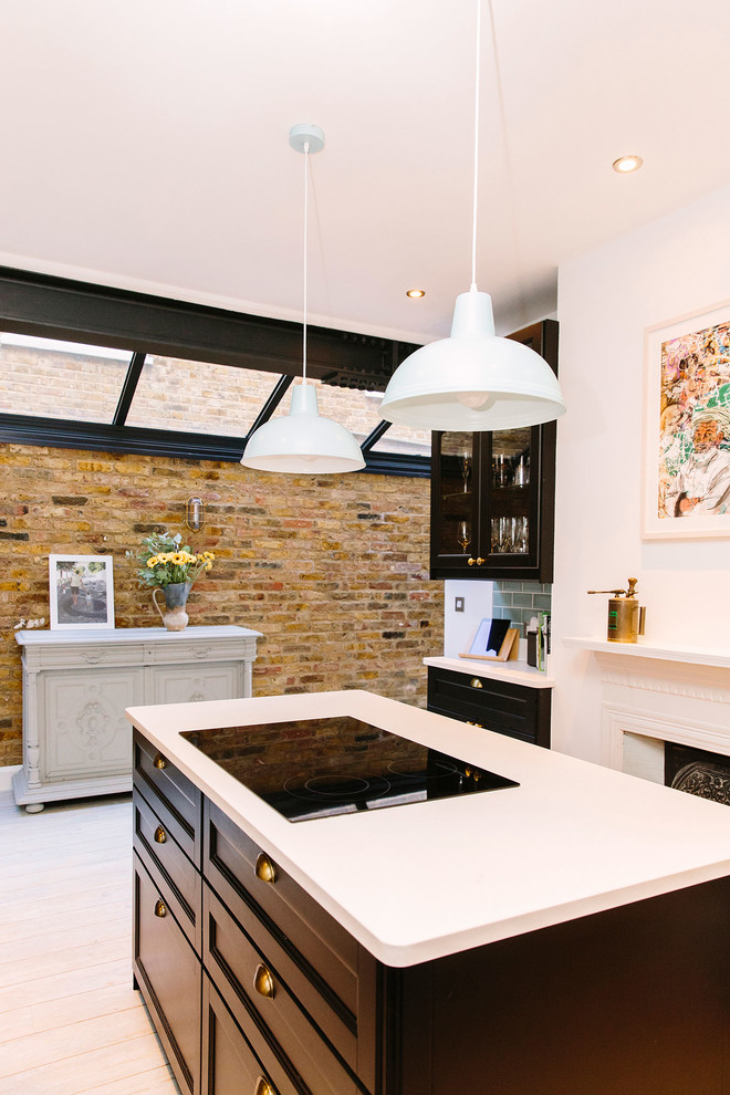 Photo of a medium sized contemporary u-shaped open plan kitchen in London with a belfast sink, shaker cabinets, grey cabinets, composite countertops, green splashback, ceramic splashback, integrated appliances, vinyl flooring, an island and grey floors.