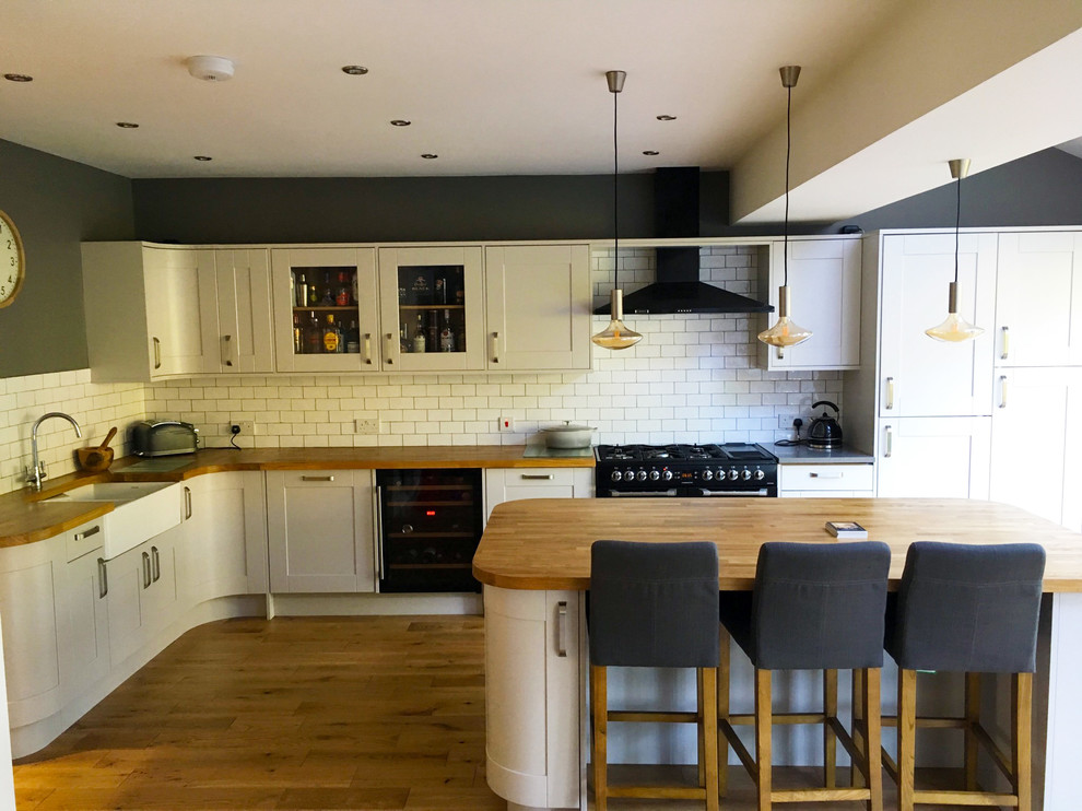 Large classic l-shaped kitchen/diner in Other with shaker cabinets, grey cabinets, wood worktops, white splashback and an island.