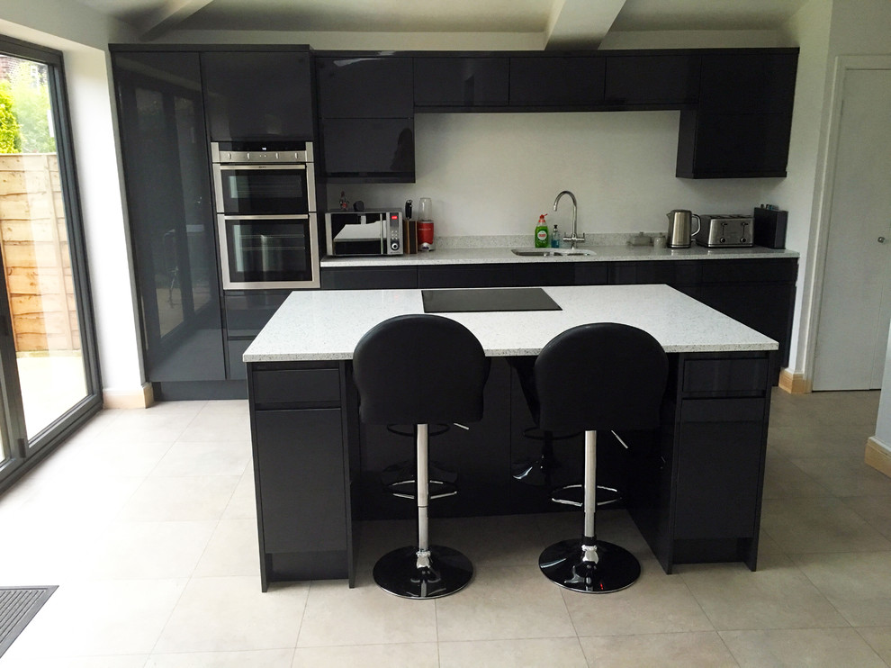 This is an example of a medium sized contemporary l-shaped kitchen/diner in Other with grey cabinets, quartz worktops and an island.