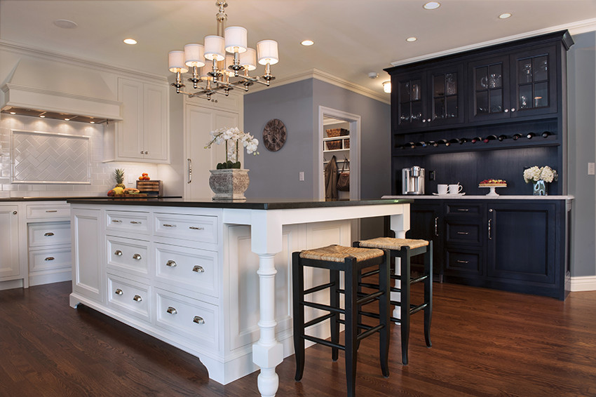 Inspiration for a timeless eat-in kitchen remodel in Boston with a farmhouse sink, white cabinets, granite countertops, white backsplash, subway tile backsplash and paneled appliances