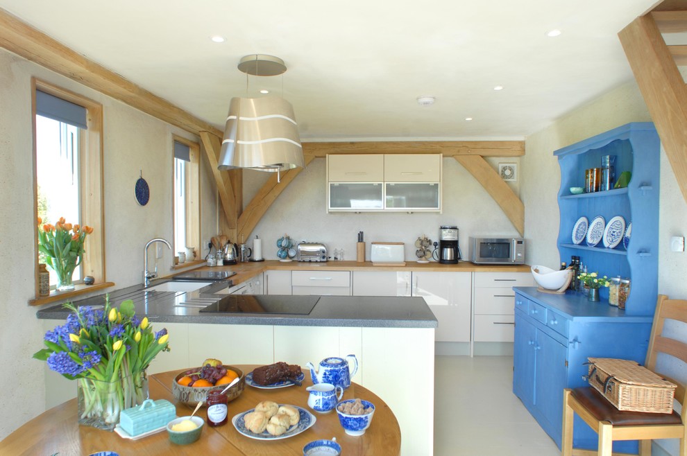 Foto di una cucina ad U country con lavello stile country, top in legno, elettrodomestici da incasso e parquet chiaro