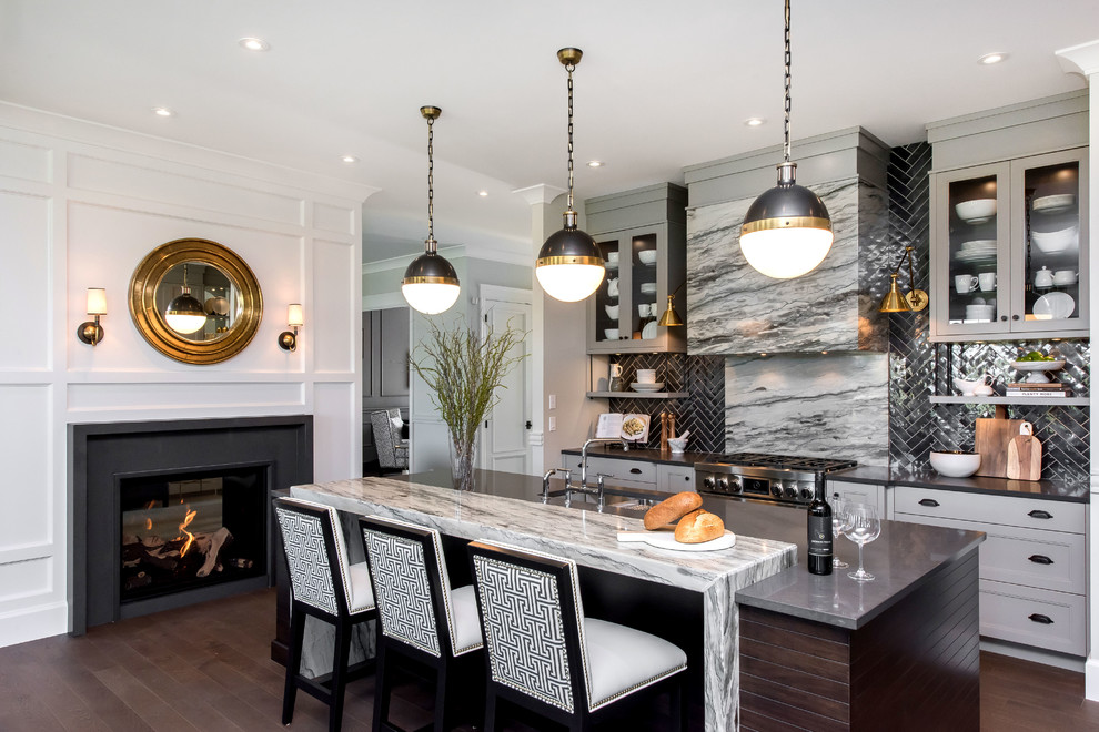 Klassische Küche mit Unterbauwaschbecken, Glasfronten, grauen Schränken, Küchenrückwand in Grau, Küchengeräten aus Edelstahl, dunklem Holzboden, Kücheninsel und braunem Boden in Vancouver