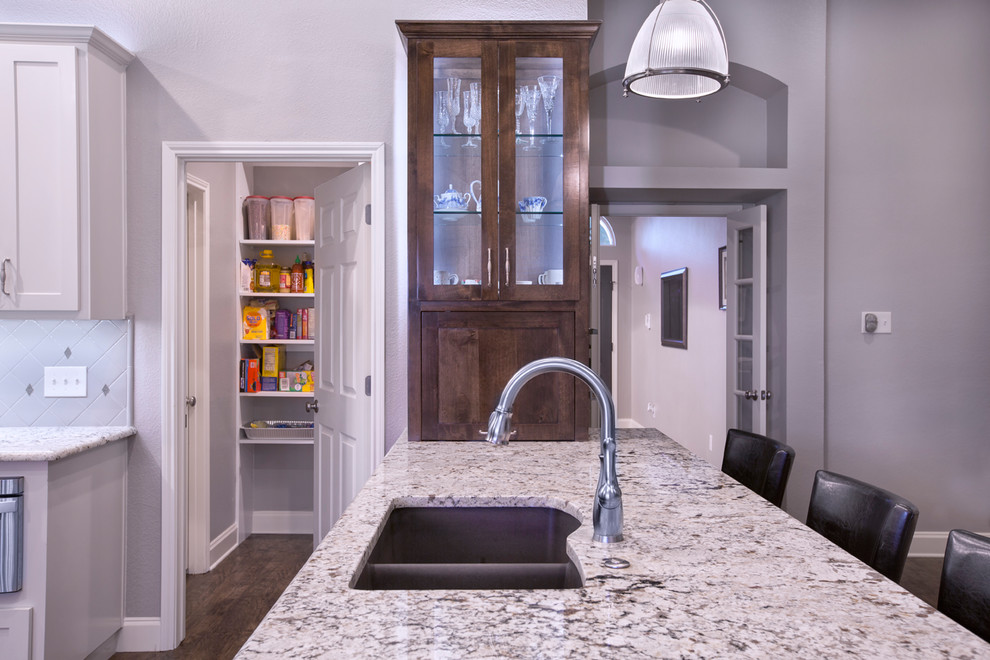 Exempel på ett mellanstort modernt kök, med en dubbel diskho, skåp i shakerstil, vita skåp, granitbänkskiva, beige stänkskydd, stänkskydd i mosaik, rostfria vitvaror, vinylgolv, en halv köksö och brunt golv