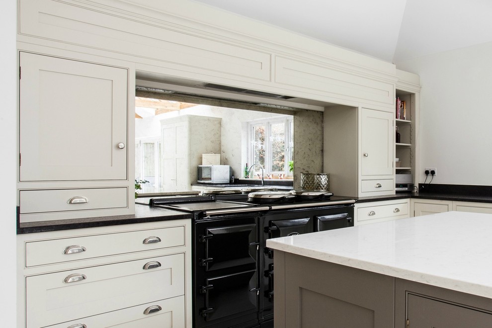 Exempel på ett stort modernt svart svart kök, med en rustik diskho, skåp i shakerstil, vita skåp, bänkskiva i kvartsit, stänkskydd med metallisk yta, spegel som stänkskydd, kalkstensgolv, en köksö, rostfria vitvaror och vitt golv
