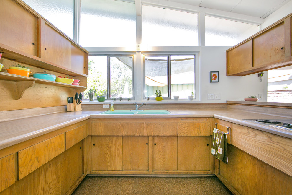 Immagine di una cucina ad U minimalista di medie dimensioni con lavello da incasso, ante in legno chiaro, top in laminato e elettrodomestici colorati