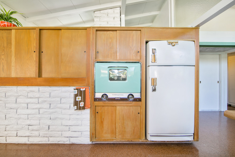 Immagine di una cucina ad U moderna di medie dimensioni con lavello da incasso, ante in legno chiaro, top in laminato e elettrodomestici colorati